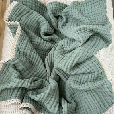 Couverture bébé douce mousseline verte sur lit Dentelle d'Éveil